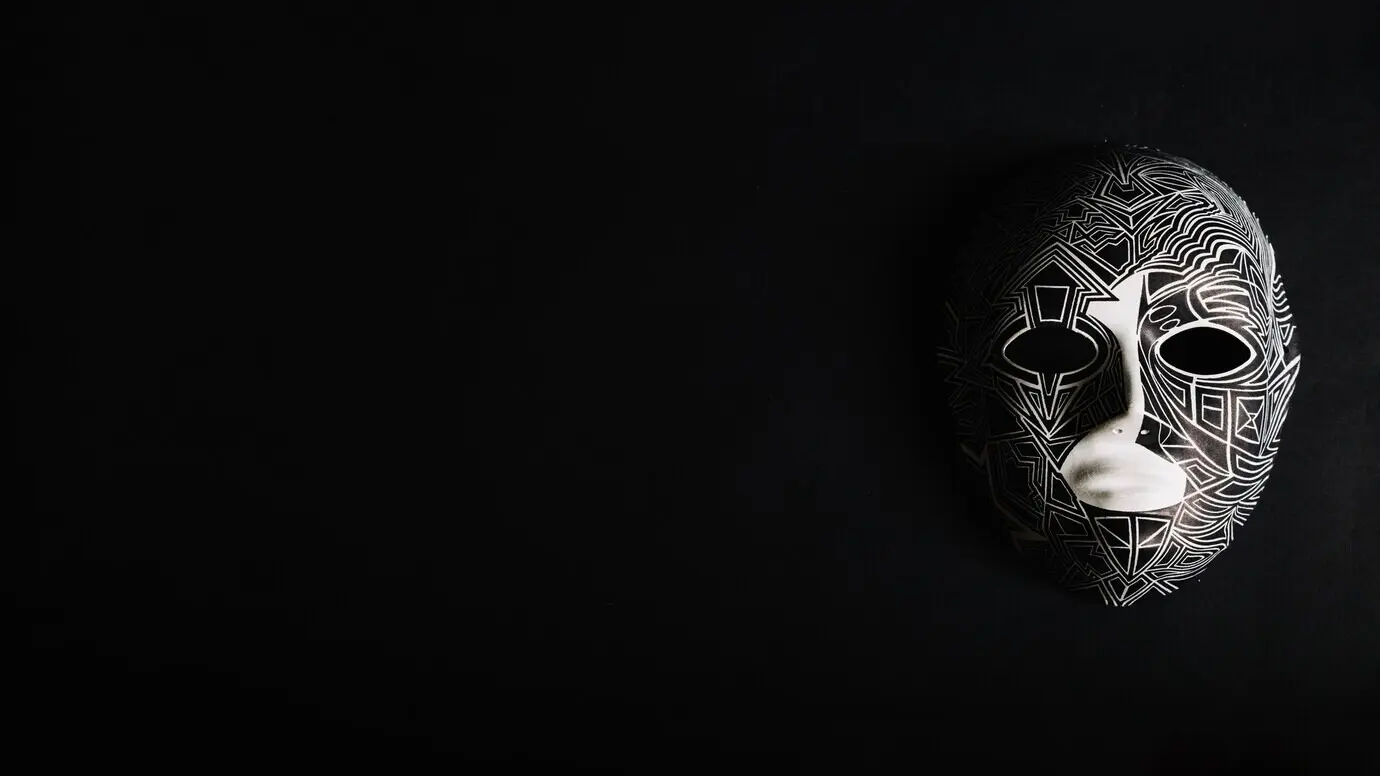 Kreative gruselige Maske vor schwarzem Hintergrund